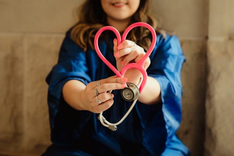 healthcare worker holding stethoscope in heart shape